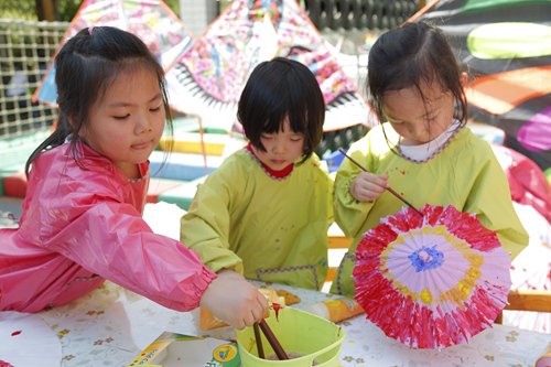 豐台六幼的孩子們用畫筆彩繪小雨傘。