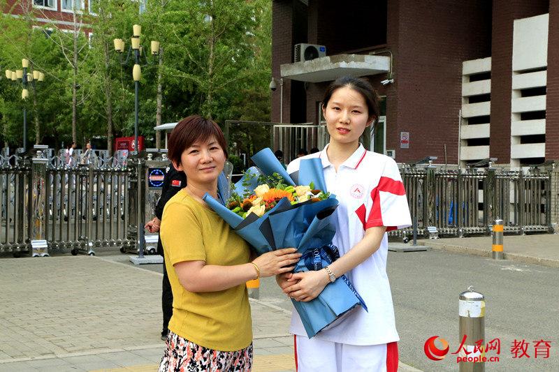 中國人民大學附屬中學考點前，曹雨荷與媽媽合影留念。李依環 攝