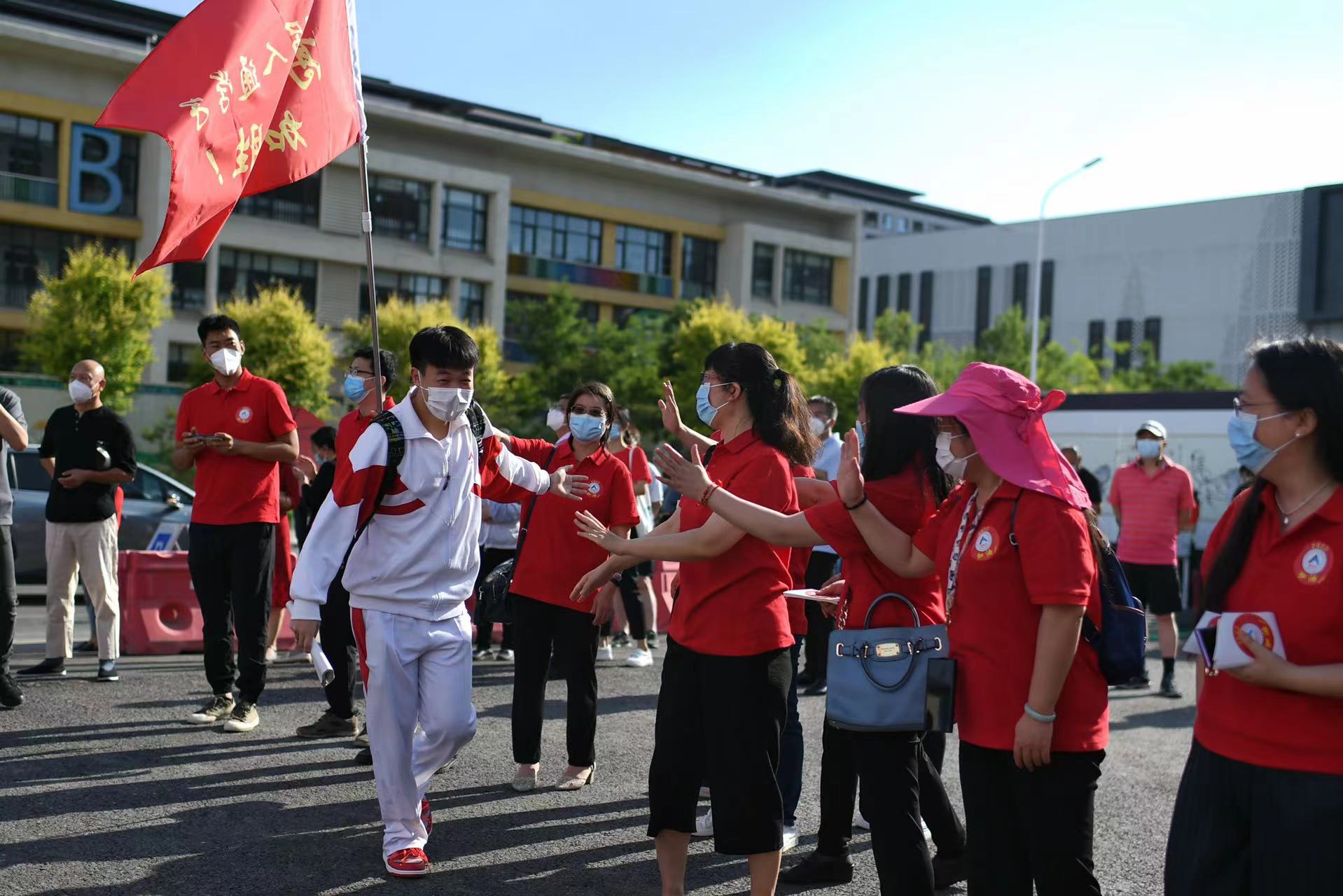 6月7日，在北京市人大附中通州校區考點，考生與送考老師擊掌加油。當日，2022年北京市高考開考，4.8萬余考生走入考場。人民網記者 翁奇羽攝