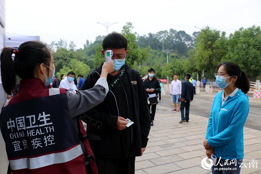 昆明市宜良縣疾控中心的工作人員正在對考生進行體溫檢測。陳正良攝