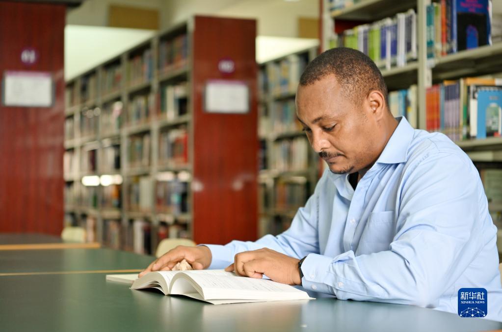 在天津職業技術師范大學圖書館，韓士蘭翻閱外文書籍（8月12日攝）。新華社記者 李然 攝