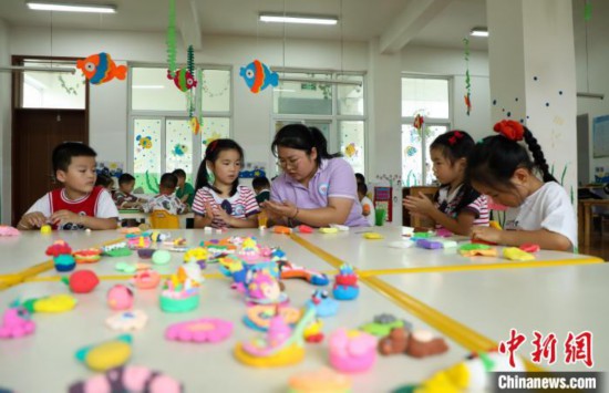 在肥西縣山南鎮中心幼兒園，孩子們在老師的指導下做彩色泥塑。　陳家樂 攝